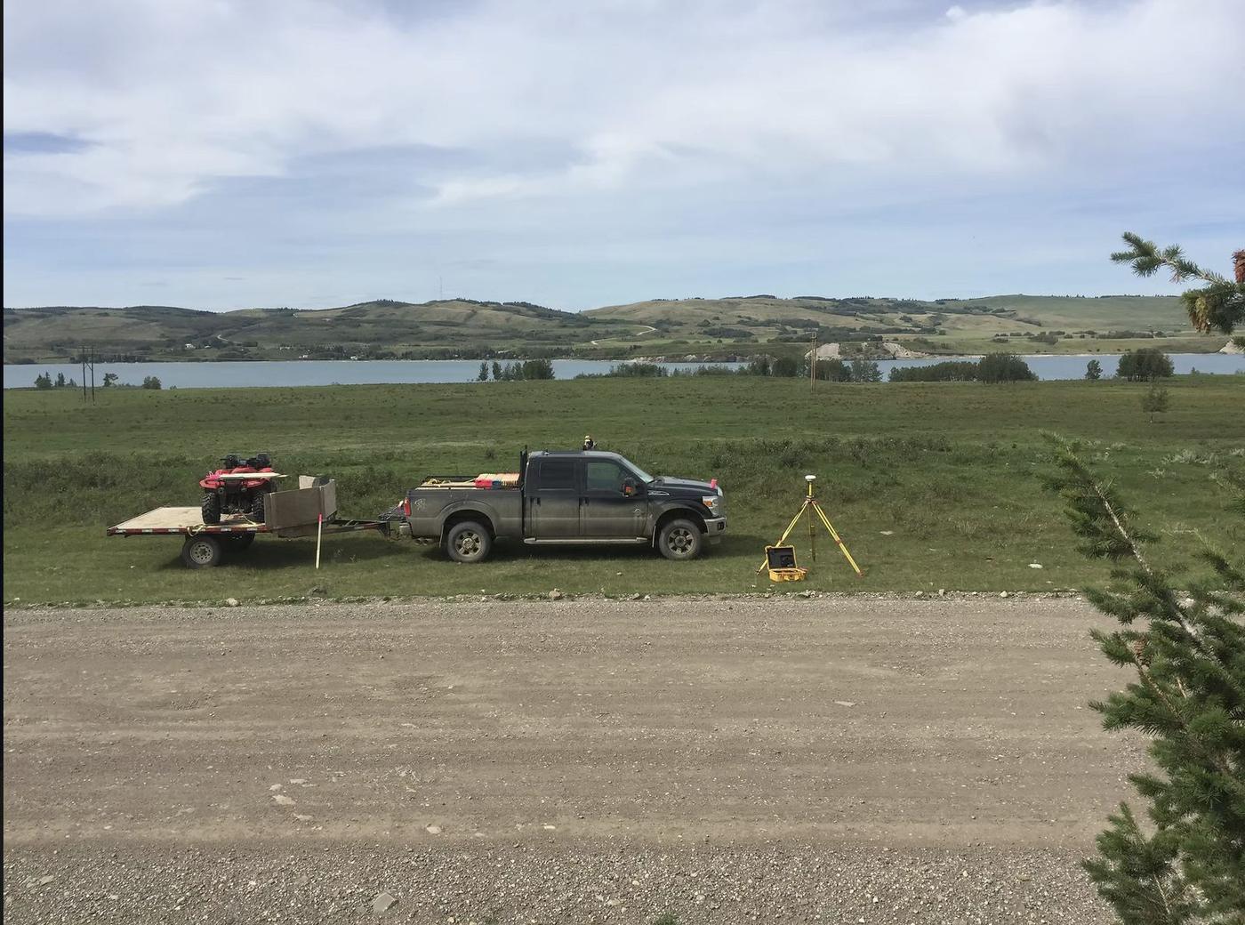 Survey truck, quad, and GNSS base station in the field